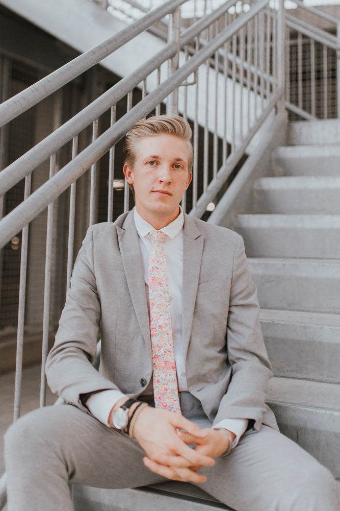 Pink Meadow tie worn with a white shirt, black belt and gray suit.