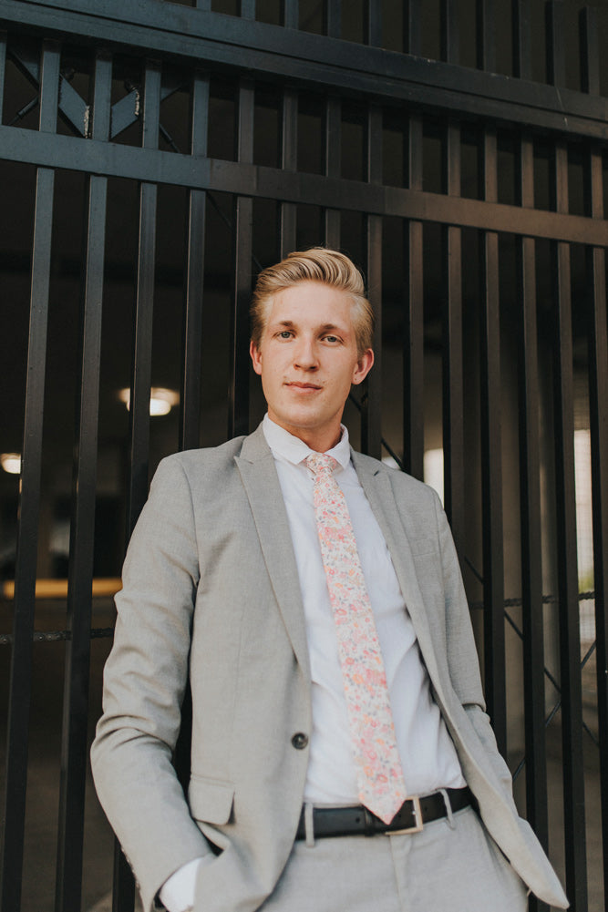 Pink Meadow tie worn with a white shirt, black belt and gray suit.