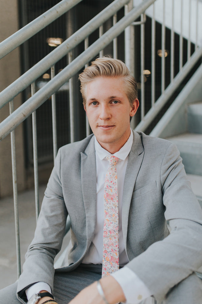 Pink Meadow tie worn with a white shirt, black belt and gray suit.