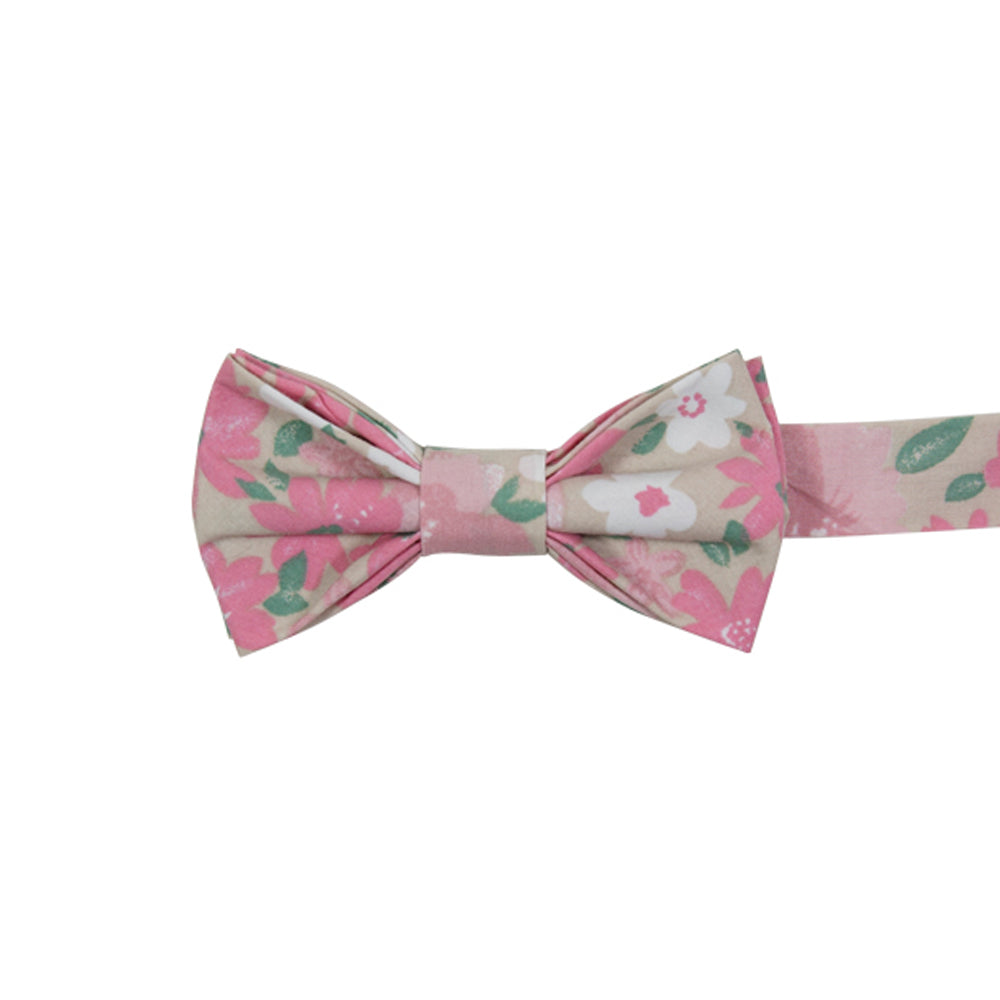 Pink Spice Pre-Tied Bow Tie. Tan champagne background with medium sized blush pink and mauve pink flowers, small white flowers, and small green leaves throughout.