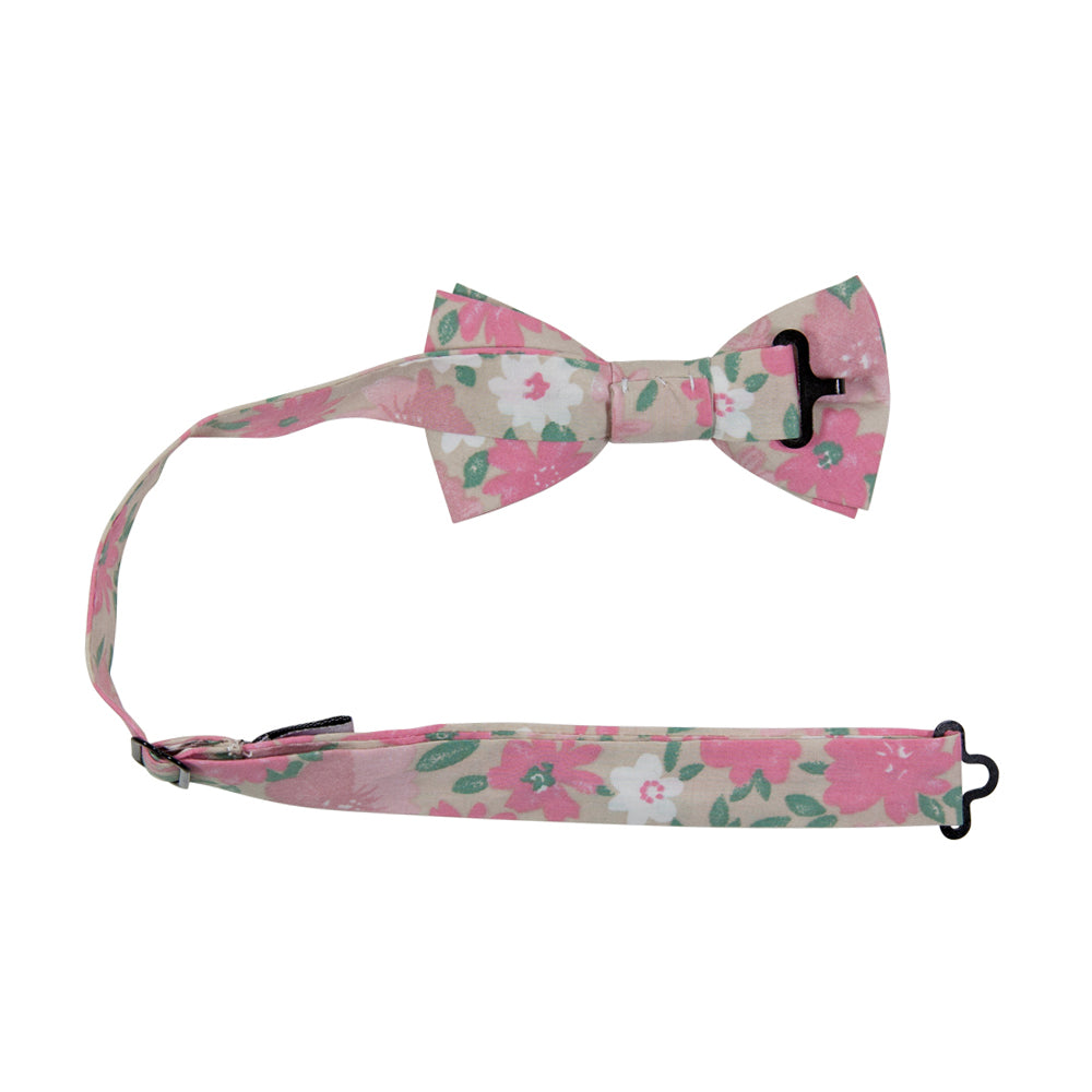 Pink Spice Pre-Tied Bow Tie with adjustable neck strap. Tan champagne background with medium sized blush pink and mauve pink flowers, small white flowers, and small green leaves throughout.