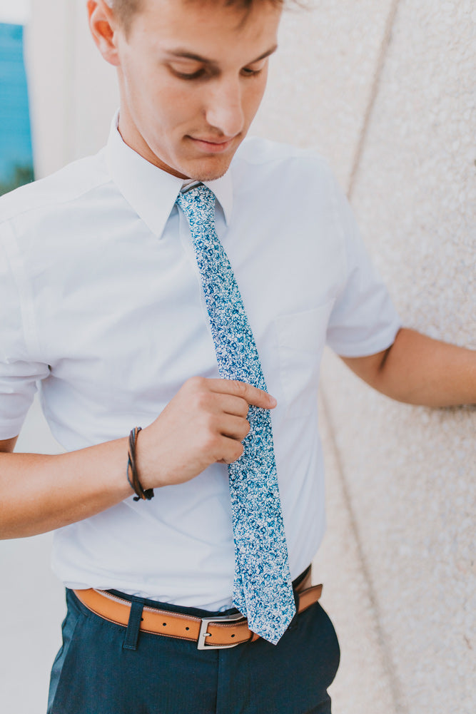 Powder tie worn with a white shirt, brown belt and navy blue pants.