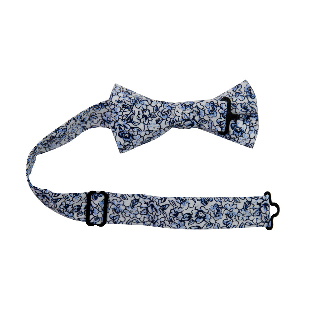 Powder Pre-Tied Bow Tie with adjustable neck strap. White background with small navy and dusty blue flowers and black stems.