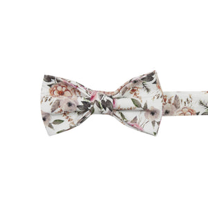 Quicksand Roses Pre-Tied Bow Tie. White background with mauve, peach and blush pink flowers. Sage green leaves and branches throughout.