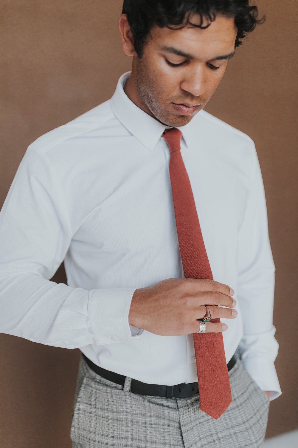 Rust Tie worn with a white shirt, black belt and gray plaid suit pants.