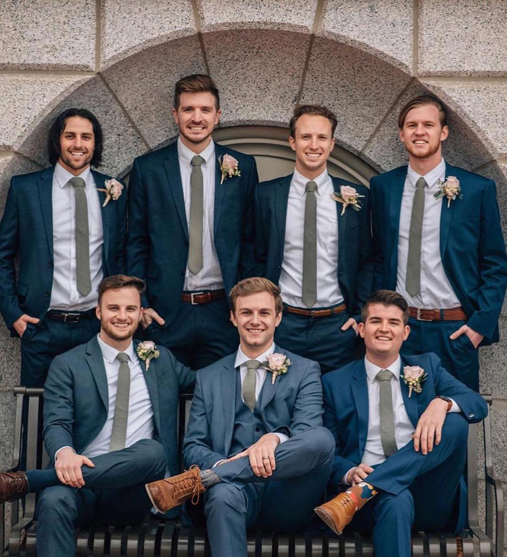 Sage tie worn by seven groomsmen wearing white shirts and blue suits.