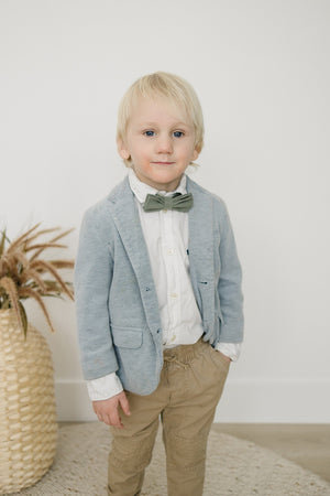 Sage pre-tied bow tie worn with a white shirt, gray blazer and tan pants. 