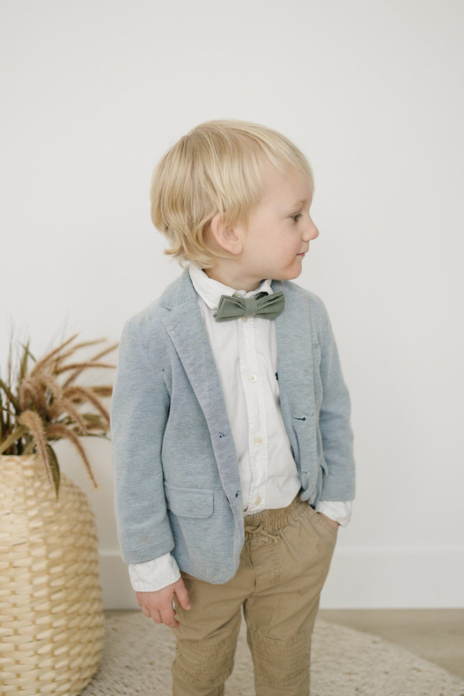 Sage pre-tied bow tie worn with a white shirt, gray blazer and tan pants. 