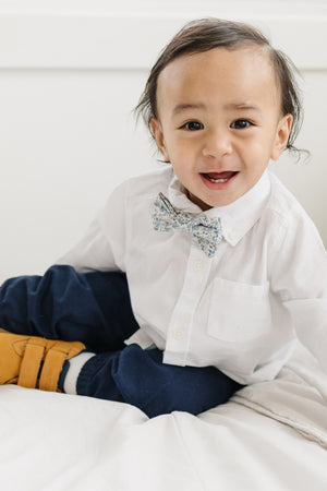 Scorpion Grass pre-tied bow tie worn with a white shirt and blue pants, brown boots.