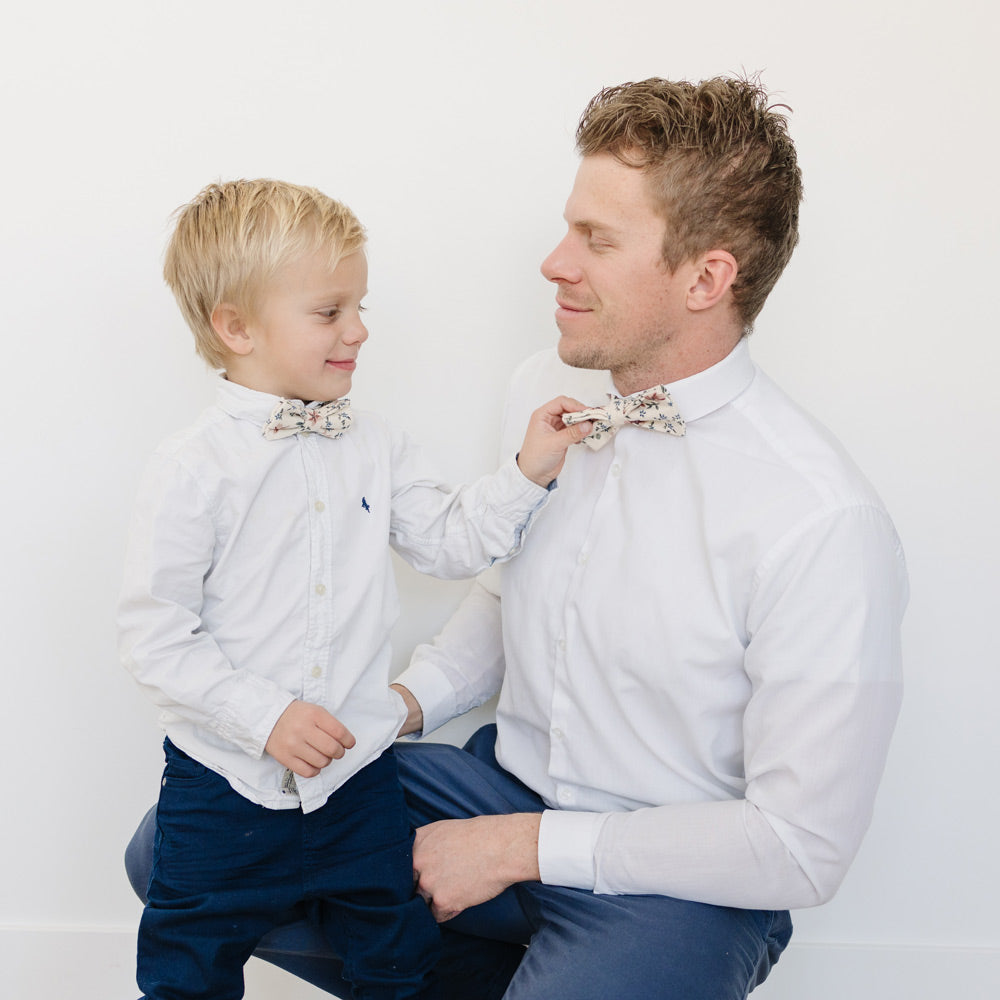 Sugar Blossom Pre-Tied Bow Ties worn by a dad and his son with white shirts and blue pants.