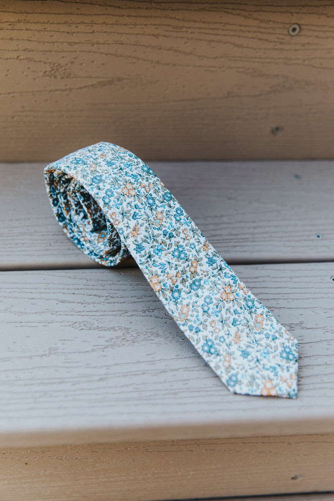 Sunny Meadow tie rolled up outside on a porch step.