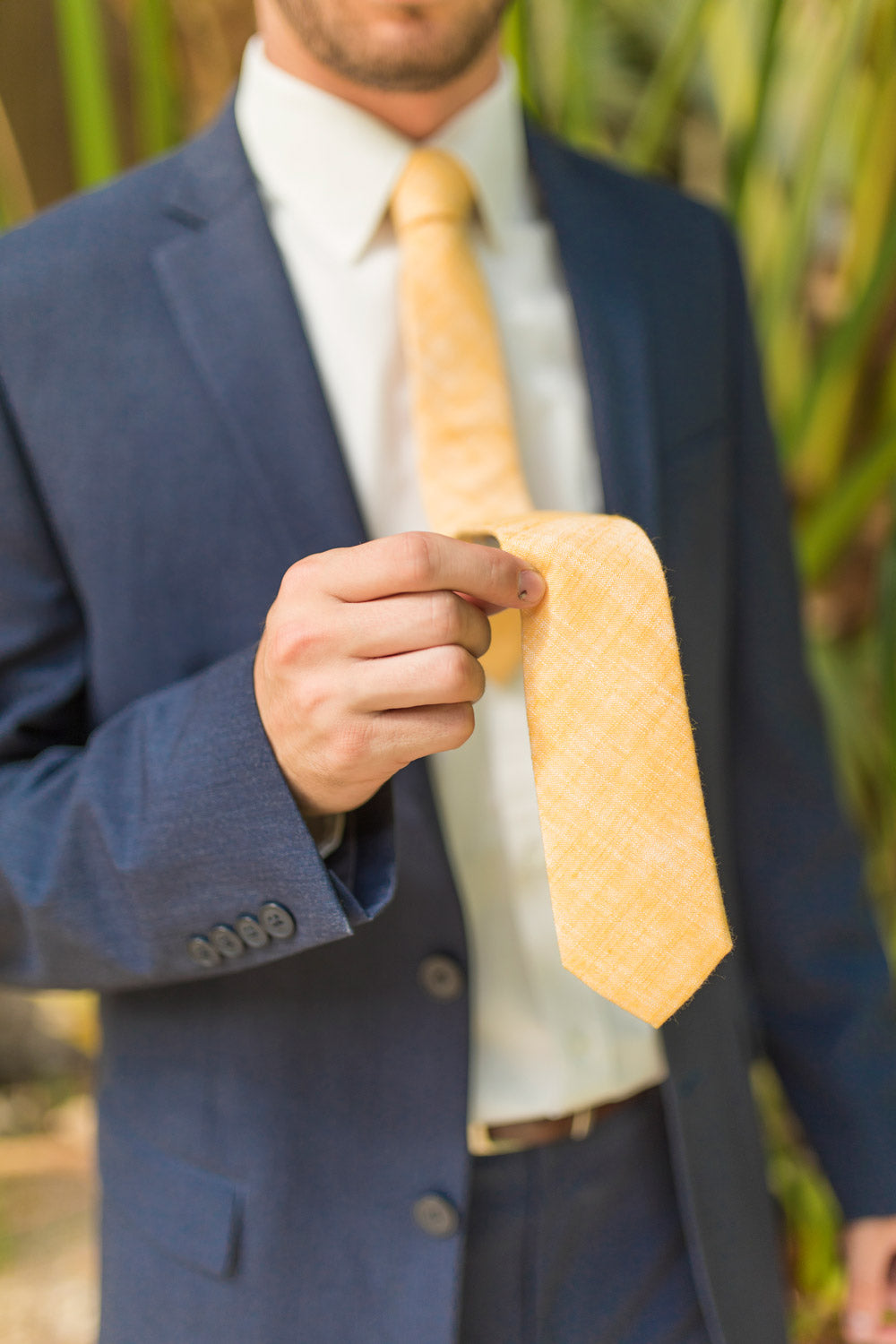 Sunset tie worn with a white shirt, brown belt and navy suit.