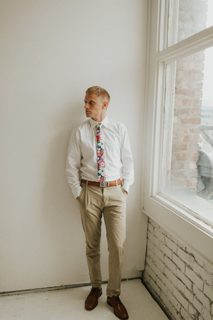 Surfs Up tie worn with a white shirt, brown belt and khaki pants.