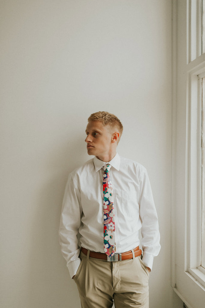 Surfs Up tie worn with a white shirt, brown belt and khaki pants.