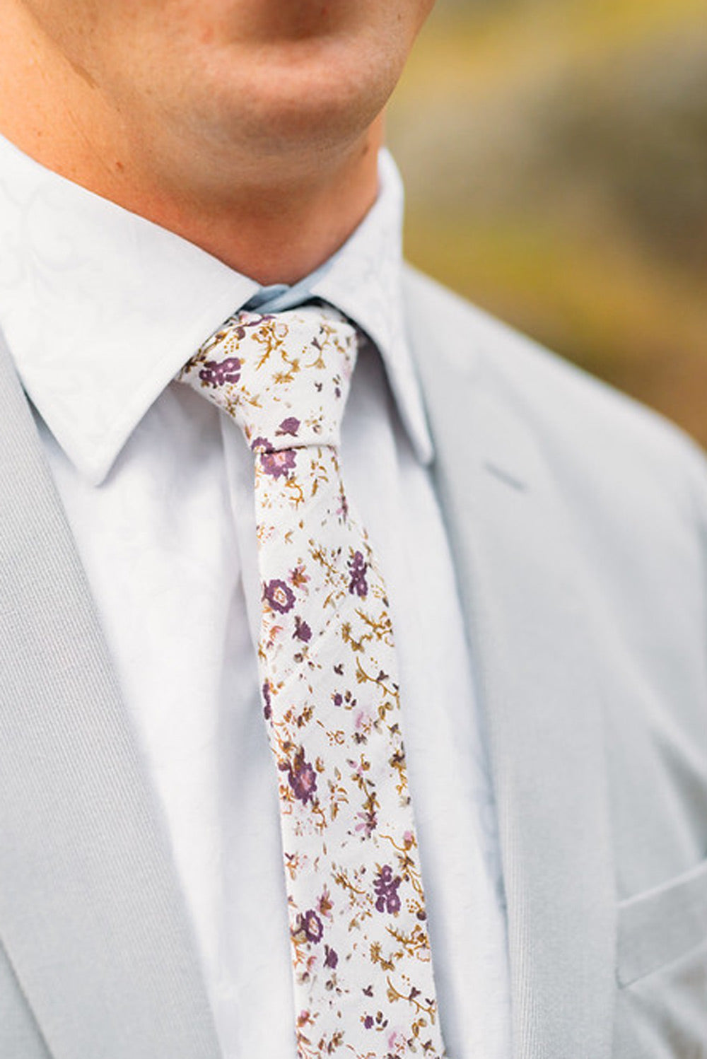 Sweetly Picked tie worn with a white shirt and light gray suit jacket.
