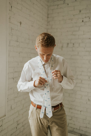 Wild Flower tie worn with a white shirt, brown belt and khaki pants.