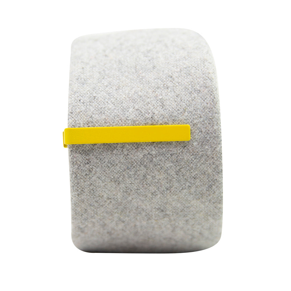 Solid yellow metal tie bar clipped onto a gray textured wool tie that is rolled up.