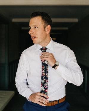 Navy Blue Floral tie worn with a white shirt, blue pants and brown belt.